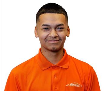 Male employee in SERVPRO shirt in front of a grey background
