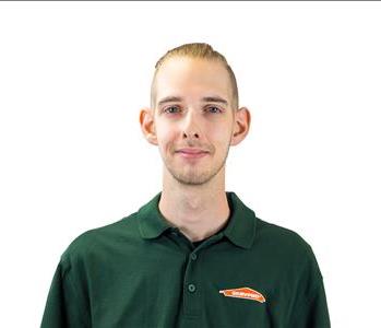 Male employee in SERVPRO shirt in front of a white backdrop